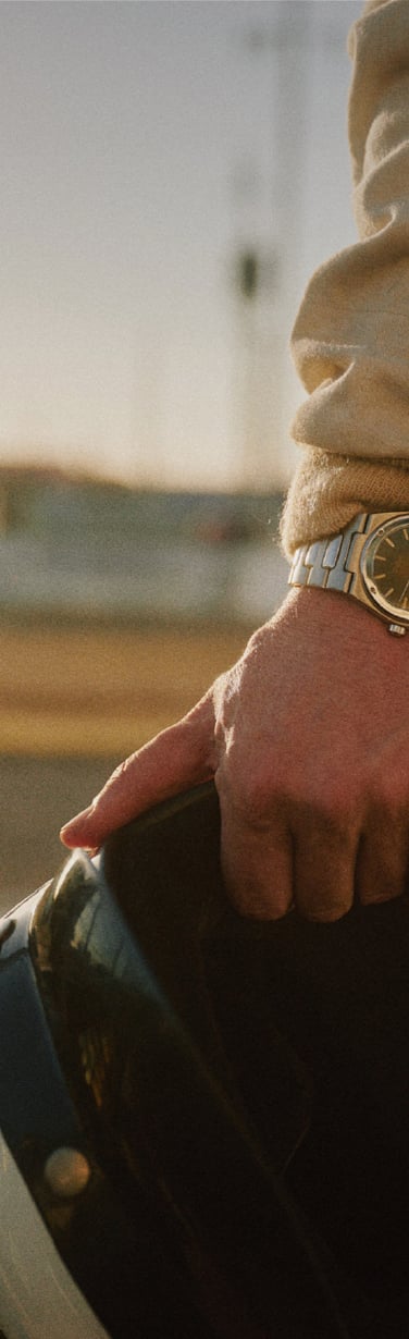 Racing car driver´s hand holding helmet and sporting the IWC Ingenieur Automatic 40 green dial.