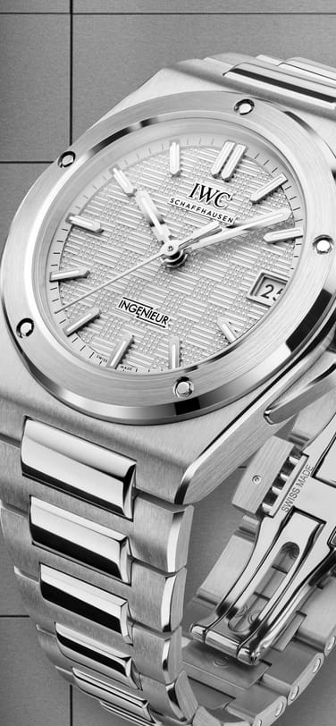 IWC Ingenieur Automatic 35 with silver plated dial, stainless steel case and bracelet against black-grey background.